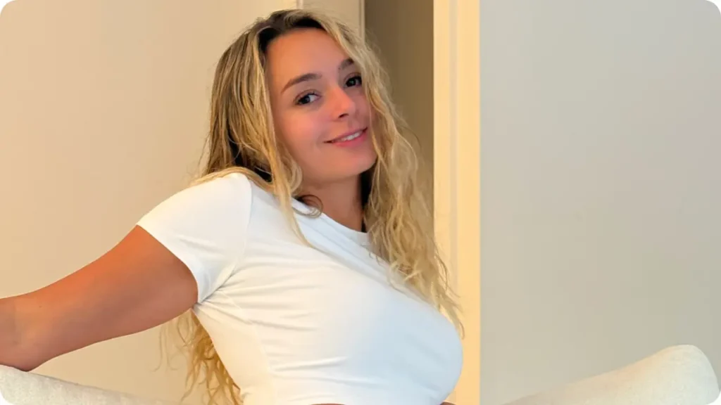 Kirstentoosweet in a white shirt sitting on couch